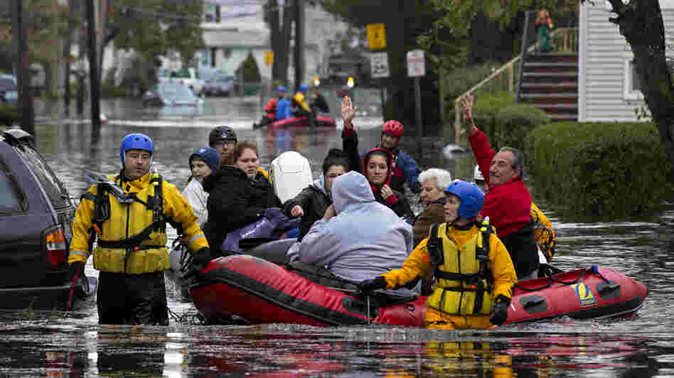 First responders rescue flood-stranded people from a sodden neighborhood in Little Ferry, N.J., on Tuesday.