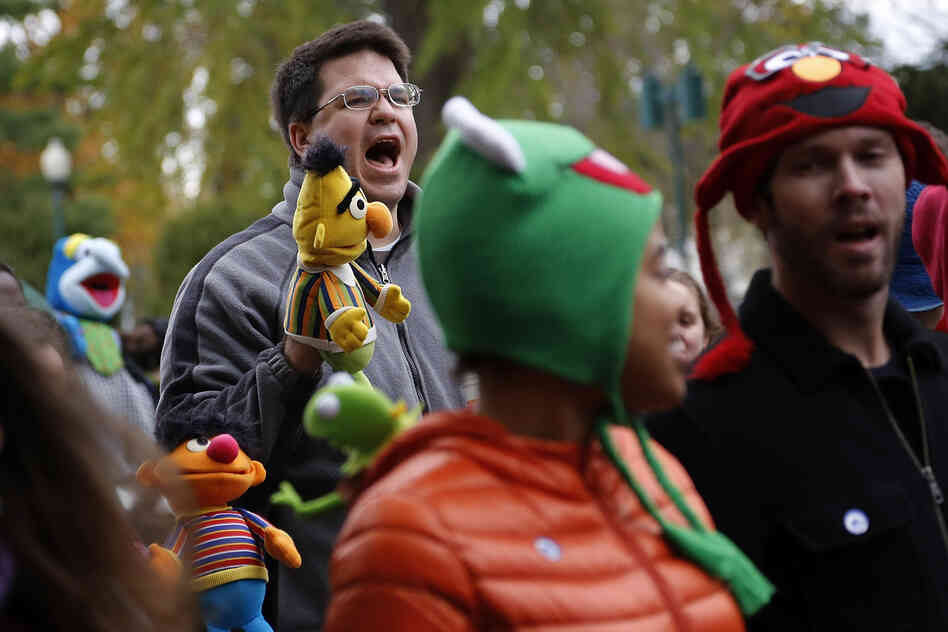 A demonstrator with a puppet of Bert, the Muppet character from Sesame Street, shouts during The Million Muppet March in Washington, D.C., on Saturday. The bipartisan rally was organized to show support for public broadcasting following Republican presidential candidate Mitt Romney's pledge to cut funding to PBS.