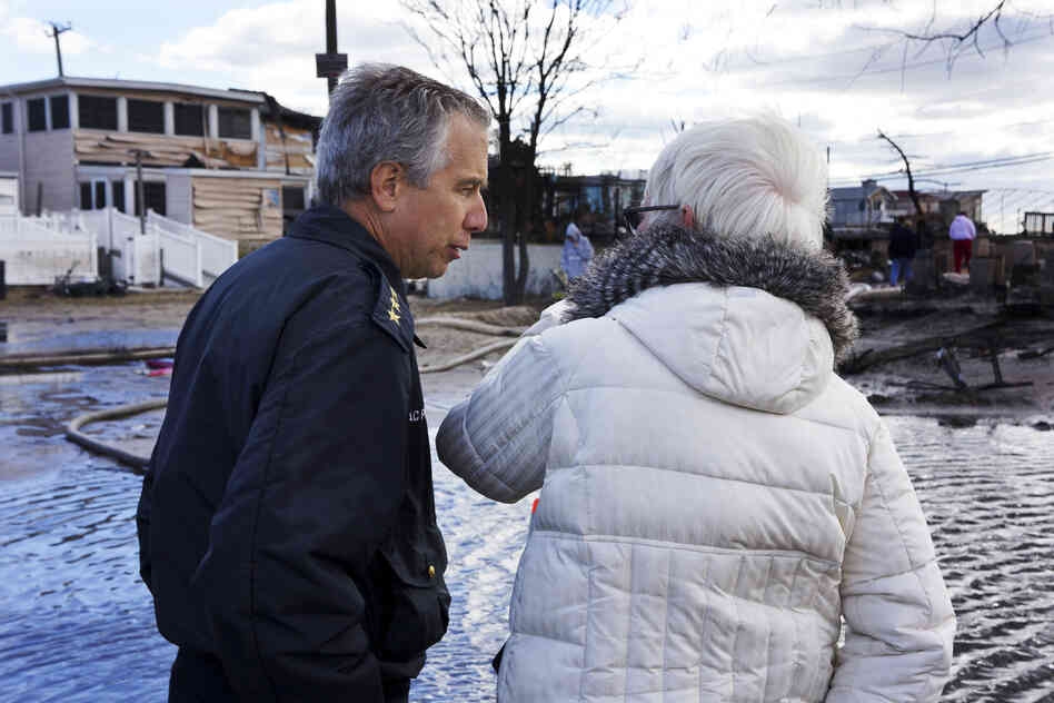 New York Fire Department Chief Joseph Pfeifer consoles a woman who lost her home. The small seaside community lost 111 homes as fires raged in the 50-mph winds of Superstorm Sandy.