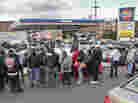 Gas customers on foot with portable containers and lines of vehicles wait for gas pumps to open at a service station on Saturday in the Brooklyn borough of New York. Mayor Michael Bloomberg said that resolving gas shortages could take days.