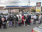 Gas customers on foot with portable containers and lines of vehicles wait for gas pumps to open at a service station on Saturday in the Brooklyn borough of New York. Mayor Michael Bloomberg said that resolving gas shortages could take days.