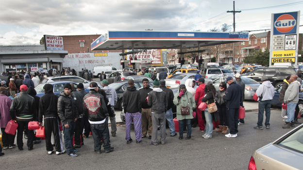 Gas customers on foot with portable containers and lines of vehicles wait for gas pumps to open at a service station on Saturday in the Brooklyn borough of New York. Mayor Michael Bloomberg said that resolving gas shortages could take days.