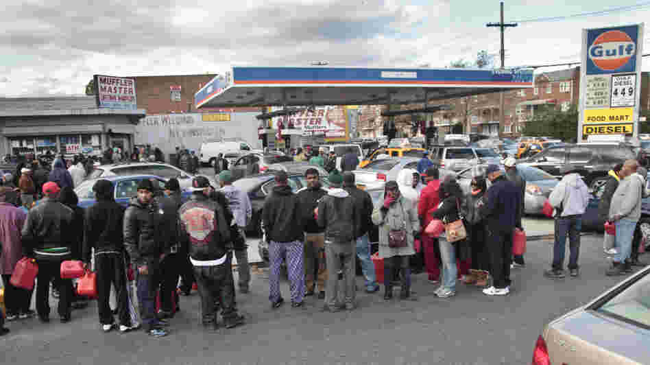 Gas customers on foot with portable containers and lines of vehicles wait for gas pumps to open at a service station on Saturday in the Brooklyn borough of New York. Mayor Michael Bloomberg said that resolving gas shortages could take days.