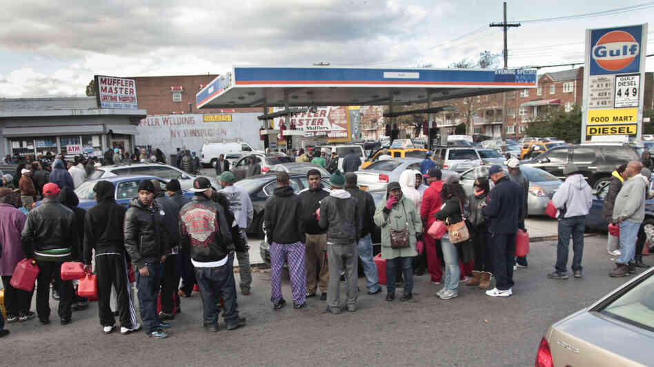 Gas customers on foot with portable containers and lines of vehicles wait for gas pumps to open at a service station on Saturday in the Brooklyn borough of New York. Mayor Michael Bloomberg said that resolving gas shortages could take days.