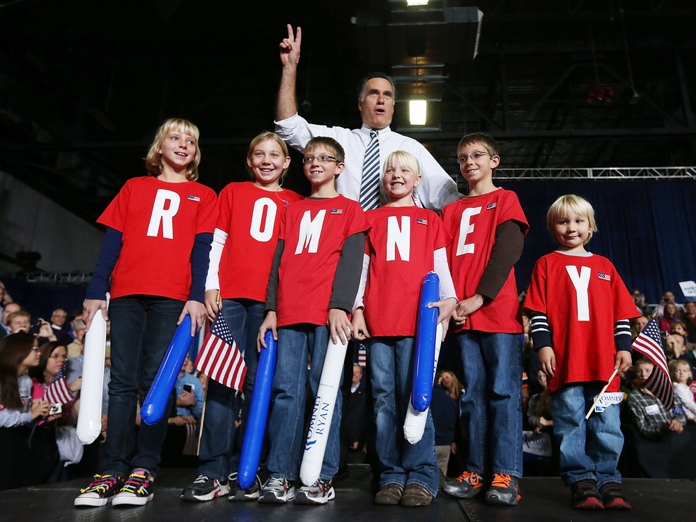 Republican presidential candidate Mitt Romney poses with children during a campaign rally in Des Moines, Iowa, on Sunday.