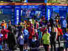 A crowd of runners stands near the barricaded Central Park finish line for the now-canceled New York Marathon on Saturday.