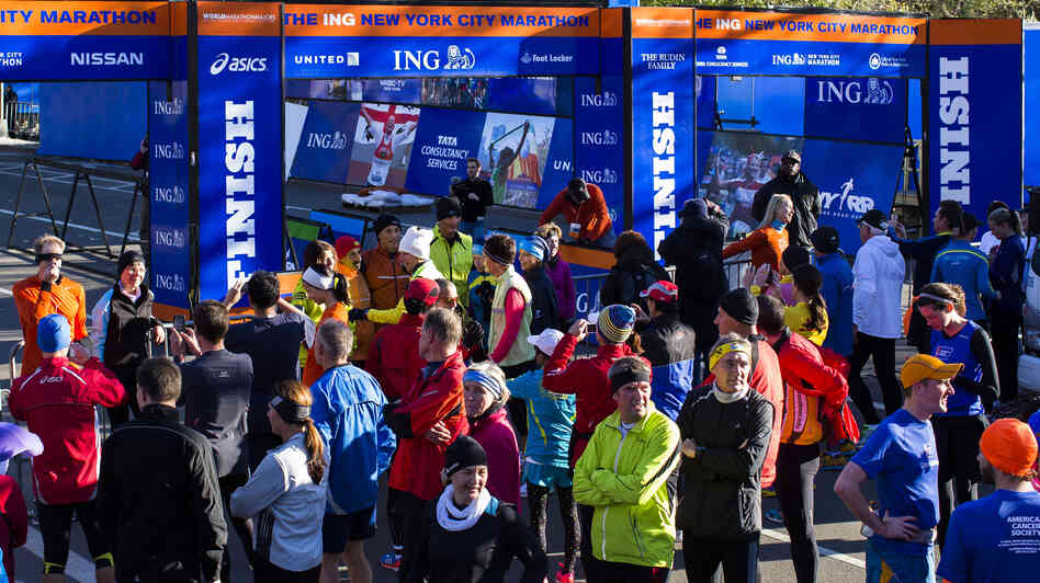 A crowd of runners stands near the barricaded Central Park finish line for the now-canceled New York Marathon on Saturday.