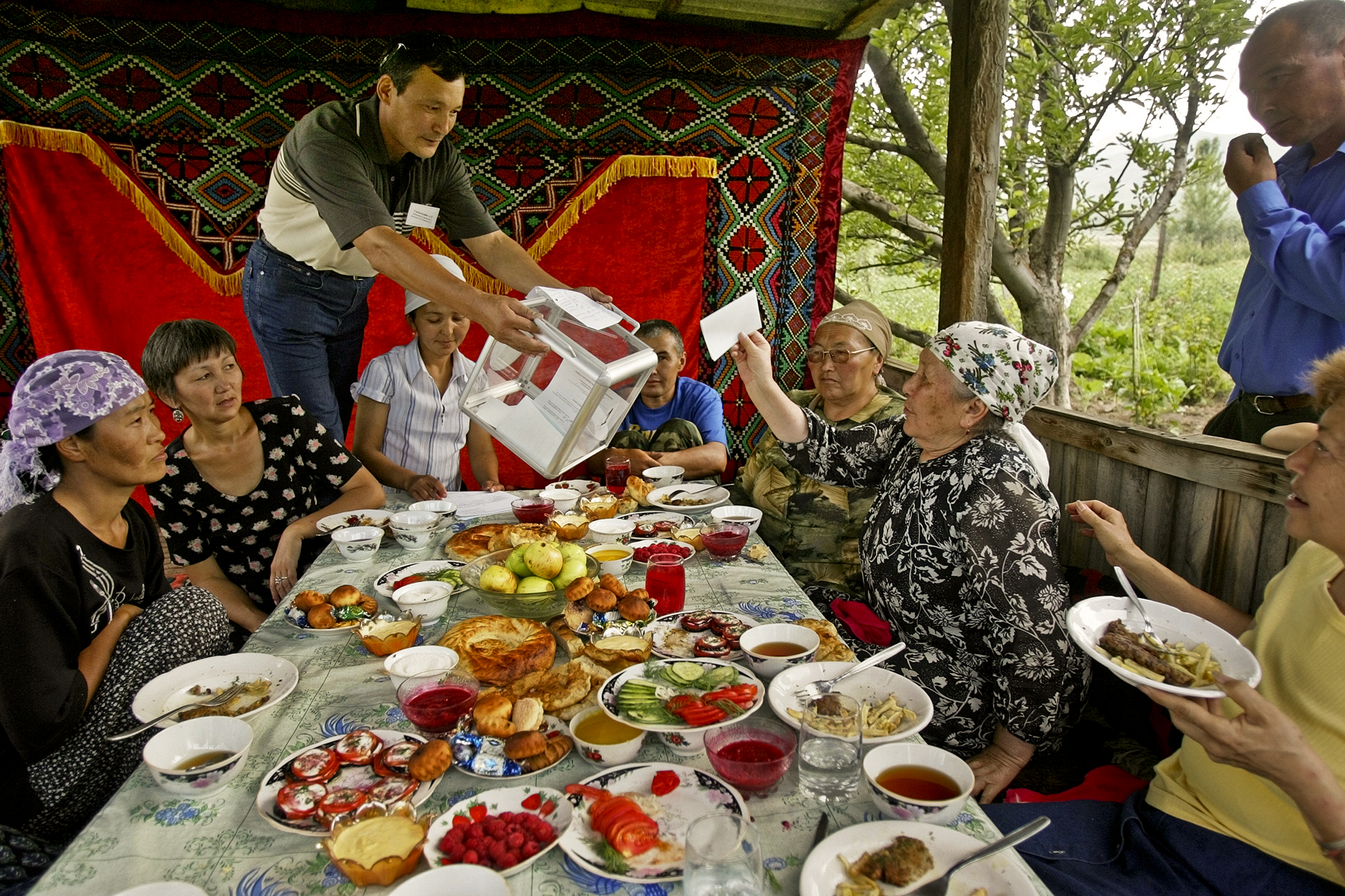In Kyrgyzstan, Toktobubu Jantaliyeva (third from right) casts a presidential ballot as she and her relatives have lunch in their country house in the village of Gornaya, 2005.