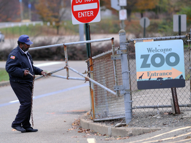A security guard closes the gate at the Pittsburgh Zoo, where a 2-year-old boy was killed Sunday.