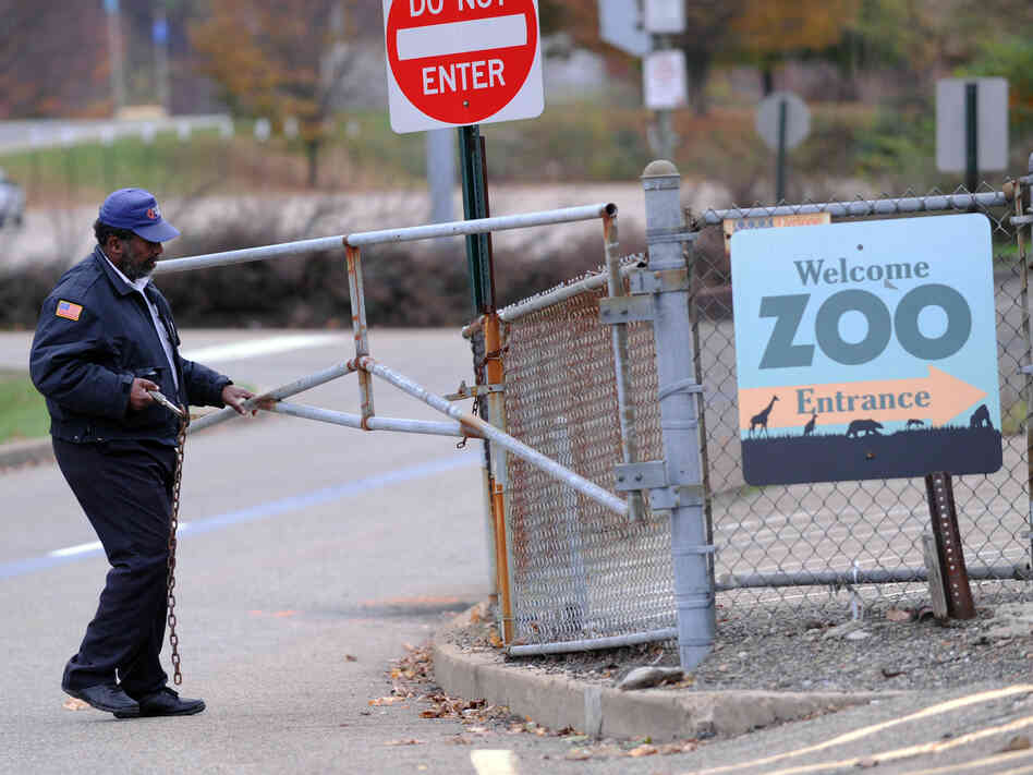 A security guard closes the gate at the Pittsburgh Zoo, where a 2-year-old boy was killed Sunday.