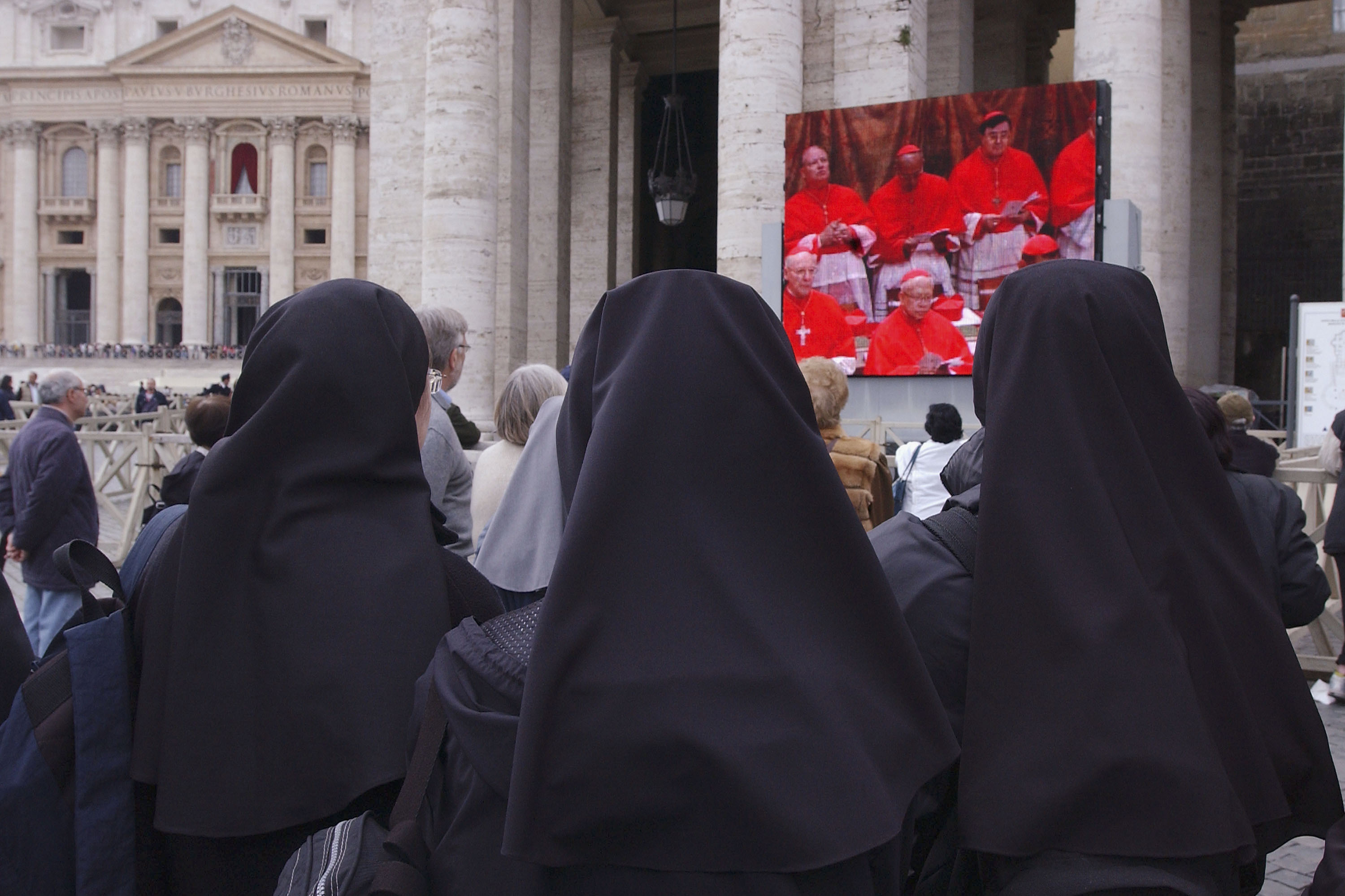 Nuns outside the Vatican watch a telecast of cardinals deliberating at the Papal Conclave to elect a new pope in 2005. The government of Vatican City, an ecclesiastical state, is overseen by the pope of the Roman Catholic church, who can only be elected by male cardinals.