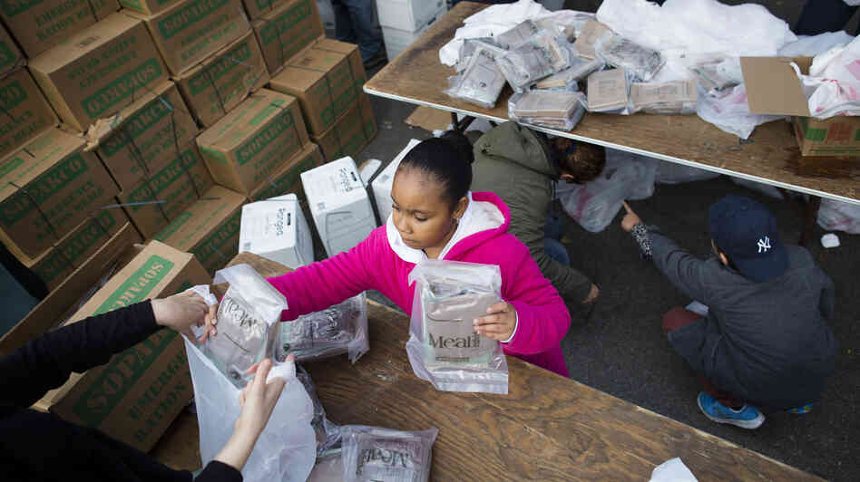 A young woman helps bag ready-to-eat meals for distribution to the residents of the Lower East Side who remain without power due to Superstorm Sandy on Friday.