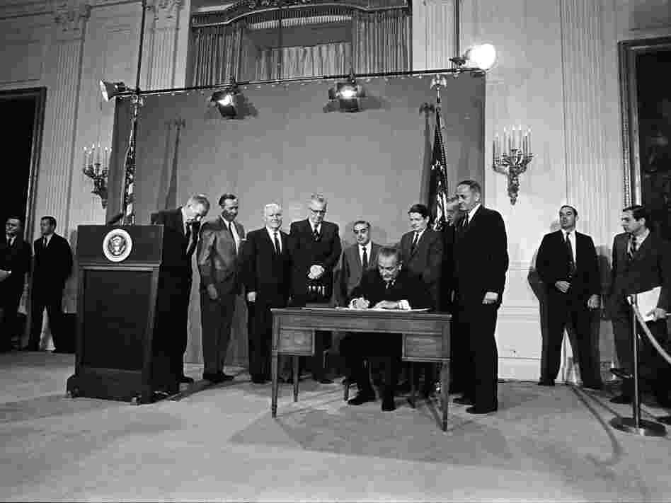 President Lyndon B. Johnson signs the Public Broadcasting Act of 1967, in the East Room of the White House.
