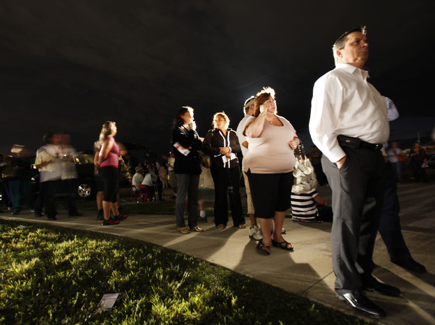 Voters line up in the dark Tuesday to cast their ballots at a polling station in Miami. President Obama said the long lines nationwide were something "we have to fix."