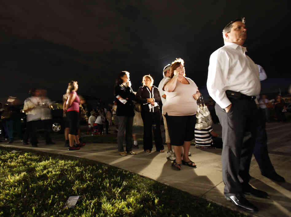 Voters line up in the dark Tuesday to cast their ballots at a polling station in Miami. President Obama said the long lines nationwide were something "we have to fix."