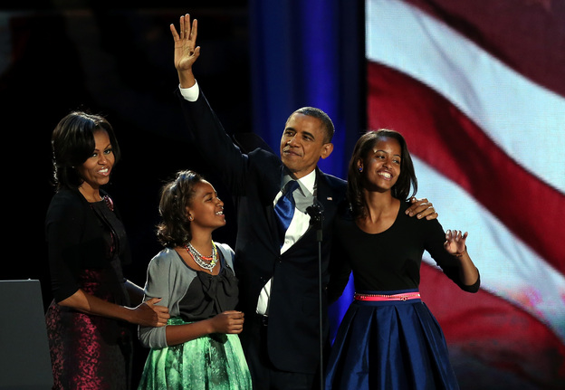 President Obama walks on stage with first lady Michelle Obama and daughters Sasha and Malia to deliver his victory speech on election night in Chicago.