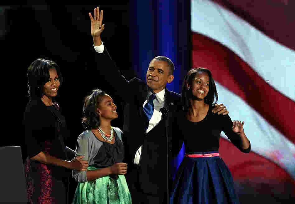 President Obama walks on stage with first lady Michelle Obama and daughters Sasha and Malia to deliver his victory speech on election night in Chicago.
