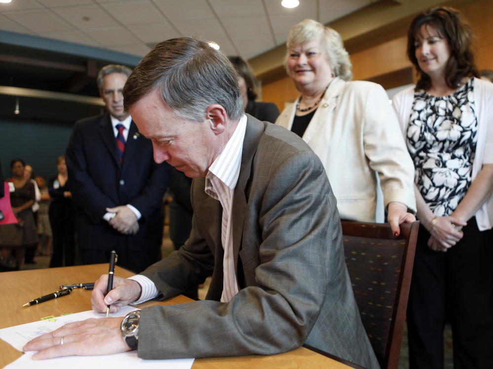 Colorado Gov. John Hickenlooper signs a bill in June 2011 to pave the way for a health insurance exchange in the state.
