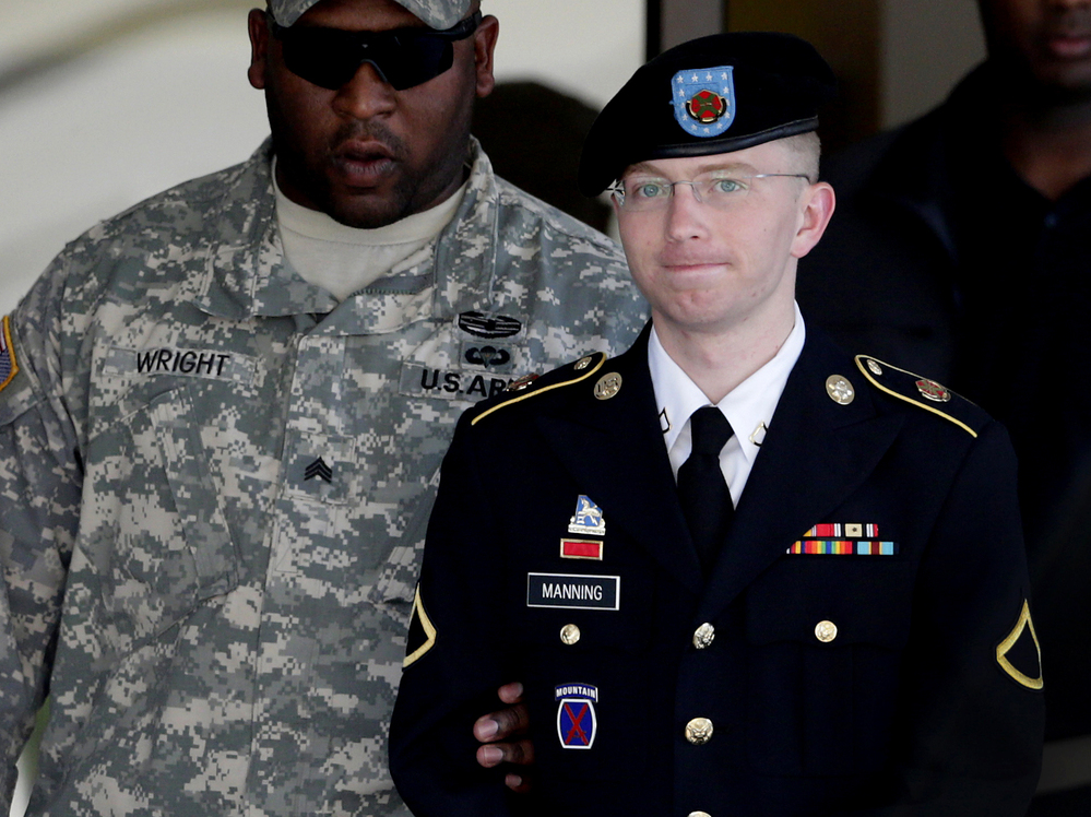 Army Pfc. Bradley Manning (right) is escorted out of a courthouse in Fort Meade, Md., on June 25, 2012. His lawyer announced that Manning, who is accused of leaking classified information to WikiLeaks, had agreed to plead guilty to lesser charges.