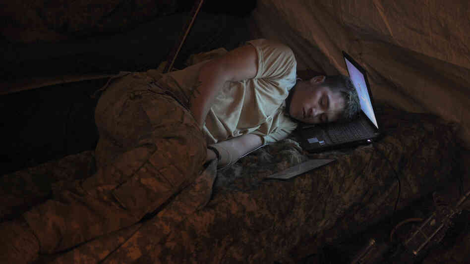 U.S. Army Pvt. Freymond Tyler sleeps on a laptop next to his gun at combat outpost Makuan in Kandahar province, Afghanistan, in 2011. U.S. Army Pvt. Freymond Tyler sleeps on a laptop next to his gun at combat outpost Makuan in Kandahar province, Afghanistan, in 2011.
