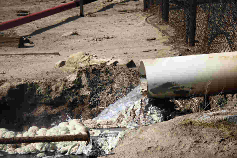 Internal EPA documents released to NPR show some EPA staffers have been trying to figure out what is in the wastewater released by oil companies. There are lots of chemicals. Some leave solid residues like these white and gray mounds. Danger signs near this outflow pipe warn that poisonous gas fumes from the water can cause respiratory irritation or suffocation.