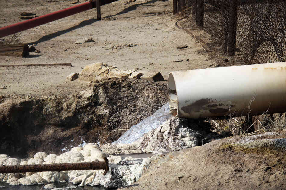 Internal EPA documents released to NPR show some EPA staffers have been trying to figure out what is in the wastewater released by oil companies. There are lots of chemicals. Some leave solid residues like these white and gray mounds. Danger signs near this outflow pipe warn that poisonous gas fumes from the water can cause respiratory irritation or suffocation.
