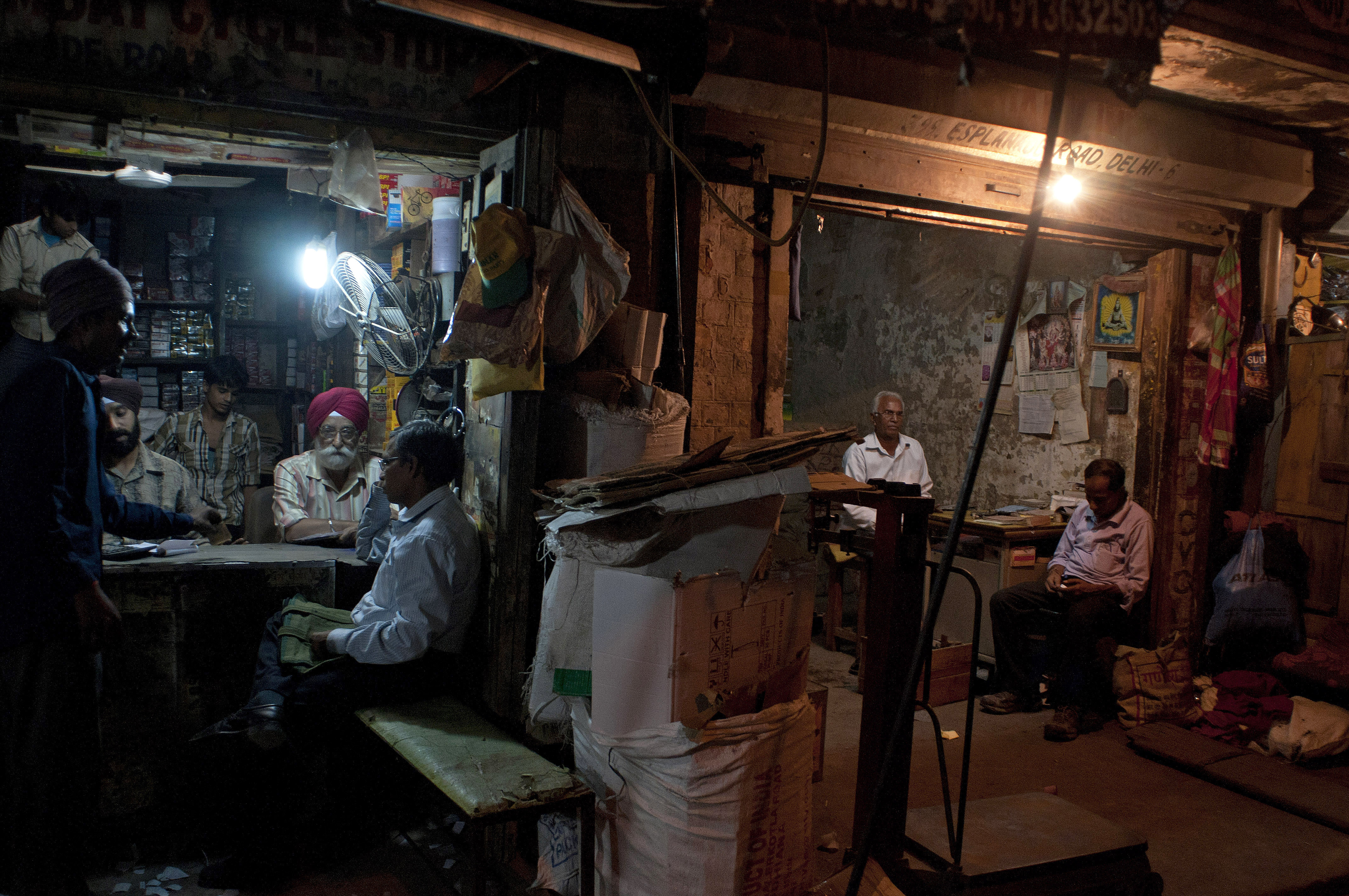 Indian workers at a spare parts store discuss business as the proprietor of a neighboring business sits in his shop in New Delhi. Indian workers at a spare parts store discuss business as the proprietor of a neighboring business sits in his shop in New Delhi.