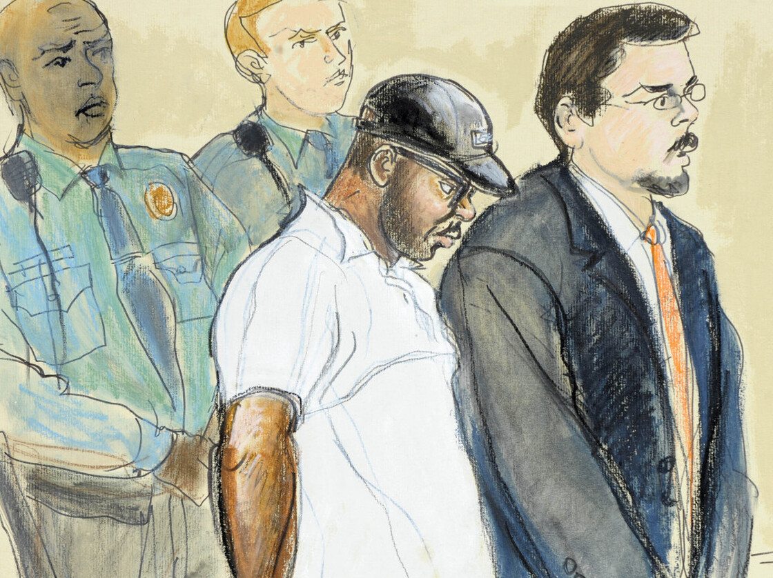 In this courtroom drawing, Aaron Thomas, stands before a judge with officers and public defender Joseph Lopez, in New Haven, Conn., on March 7, 2011.