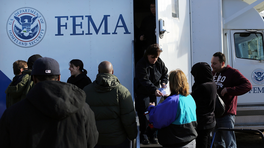 Residents wait for information from FEMA in the Rockaway neighborhood of Queens, N.Y. Superstorm Sandy washed away a large section of the iconic boardwalk here on Nov. 2.