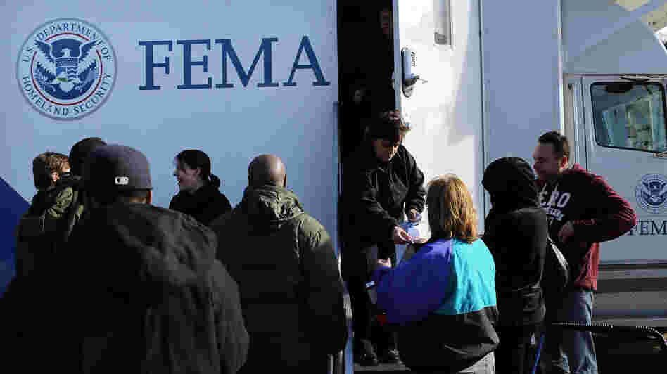 Residents wait for information from FEMA in the Rockaway neighborhood of Queens, N.Y. Superstorm Sandy washed away a large section of the iconic boardwalk here on Nov. 2.