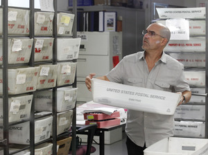 A worker prepares boxes of absentee ballots to be scanned at the Miami-Dade County Elections Department on Tuesday. A worker prepares boxes of absentee ballots to be scanned at the Miami-Dade County Elections Department on Tuesday.