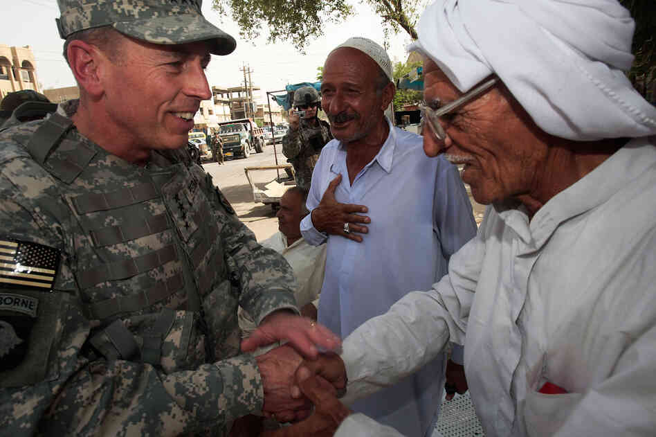 Gen. David Petraeus greets an Iraqi man at a tea shop in Baghdad in 2007. In 2011, Petraeus left the Army to become CIA director. He resigned Friday, citing an extramarital affair.