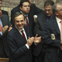 Greek Prime Minister Antonis Samaras and lawmakers from his New Democracy applaud after voting on the country's 2013 budget in Athens early Monday. Greek lawmakers approved the country's 2013 austerity budget, an essential step in Greece's efforts to persuade its international creditors to unblock a vital rescue loan installment without which the country will go bankrupt.