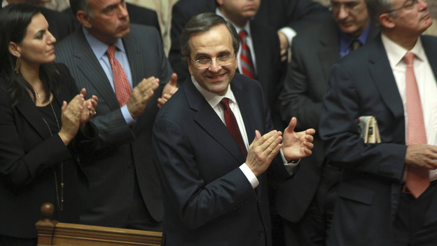 Greek Prime Minister Antonis Samaras and lawmakers from his New Democracy applaud after voting on the country's 2013 budget in Athens early Monday. Greek lawmakers approved the country's 2013 austerity budget, an essential step in Greece's efforts to persuade its international creditors to unblock a vital rescue loan installment without which the country will go bankrupt.