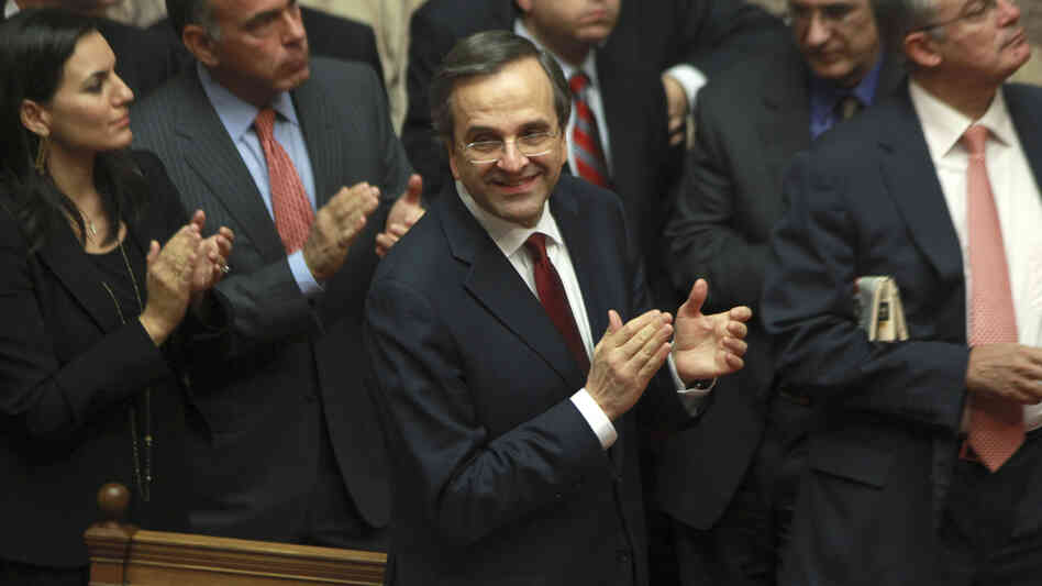 Greek Prime Minister Antonis Samaras and lawmakers from his New Democracy applaud after voting on the country's 2013 budget in Athens early Monday. Greek lawmakers approved the country's 2013 austerity budget, an essential step in Greece's efforts to persuade its international creditors to unblock a vital rescue loan installment without which the country will go bankrupt.