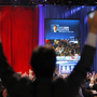 A supporter of President Barack Obama raises his arms as it is announced that Obama was re-elected during an election night watch party in Chicago.