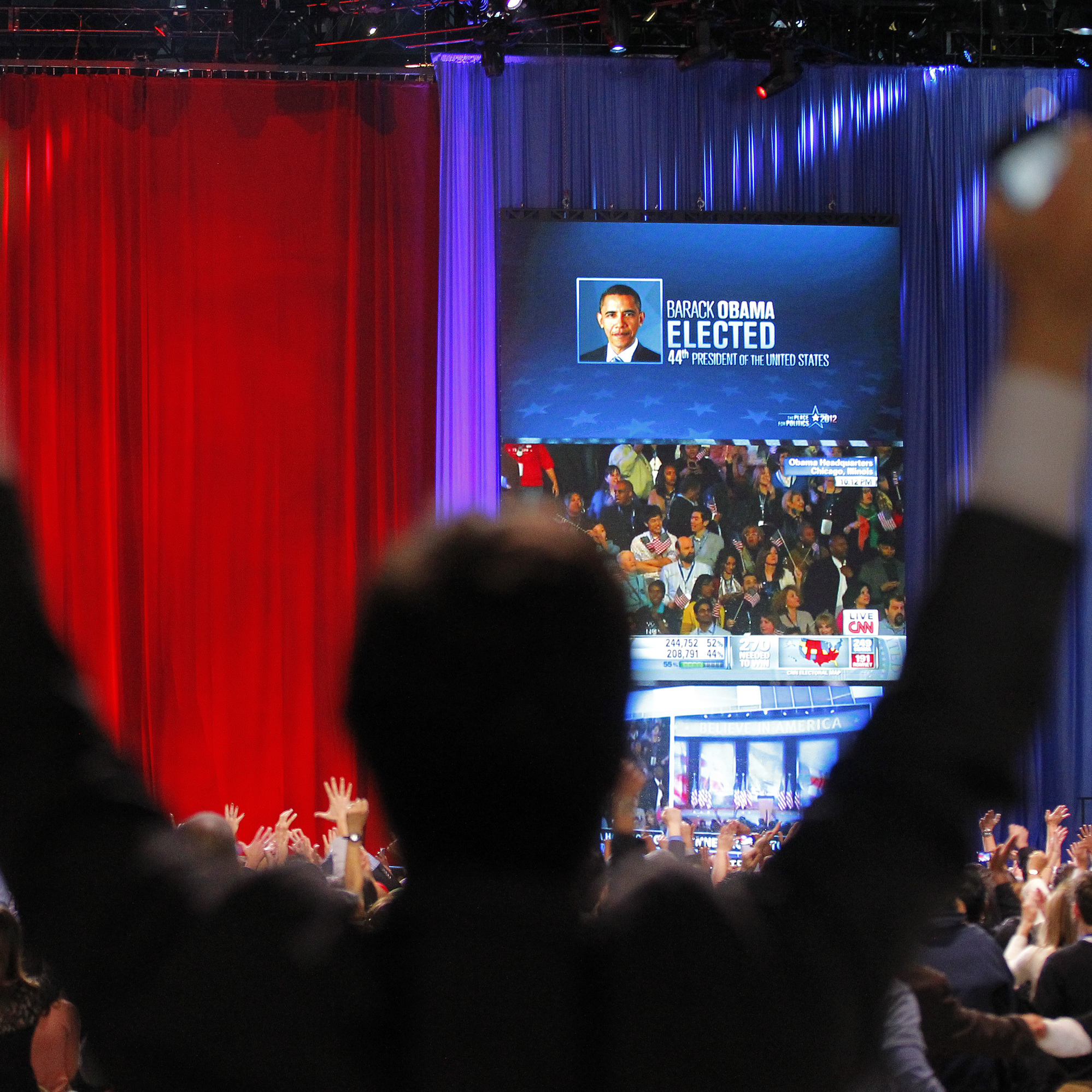 A supporter of President Barack Obama raises his arms as it is announced that Obama was re-elected during an election night watch party in Chicago.