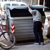 A man searches through trash bins in Girona, Spain. Across Spain, people are increasingly dumpster diving for scraps of food or metal.