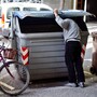 A man searches through trash bins in Girona, Spain. Across Spain, people are increasingly dumpster diving for scraps of food or metal. A man searches through trash bins in Girona, Spain. Across Spain, people are increasingly dumpster diving for scraps of food or metal.