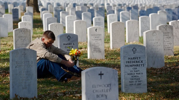 Marine Corps Capt. Jeff Cliffe, sat to reflect Sunday next to the grave of his grandfather and grandmother at Arlington National Cemetery in Virginia.
