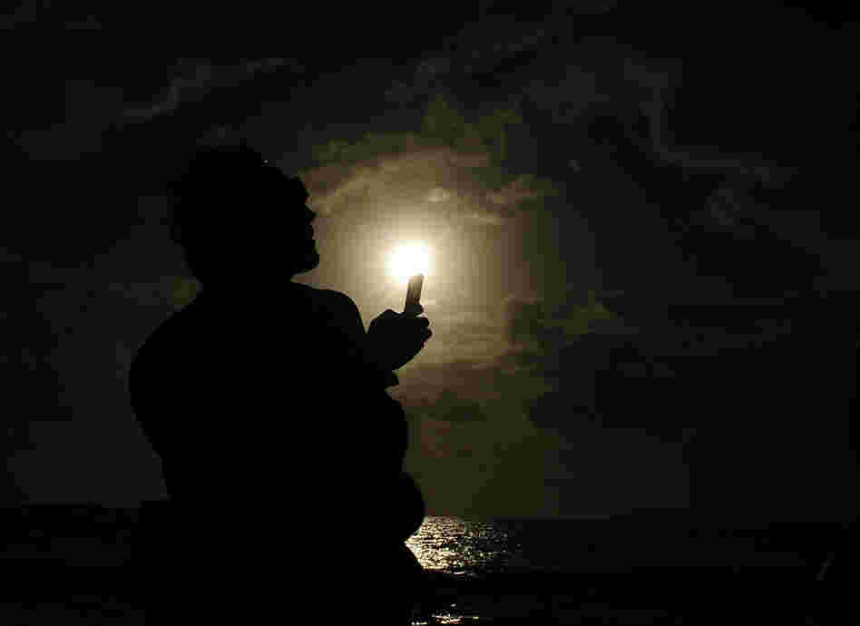 A spectator attempts to take a picture with his phone during the solar eclipse on Wednesday in Palm Cove, Australia. Thousands of eclipse-watchers have gathered in part of North Queensland to enjoy the solar eclipse, the first in Australia in a decade. A spectator attempts to take a picture with his phone during the solar eclipse on Wednesday in Palm Cove, Australia. Thousands of eclipse-watchers have gathered in part of North Queensland to enjoy the solar eclipse, the first in Australia in a decade.