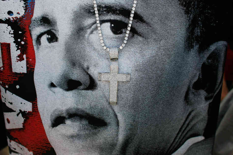 A cross hangs in front of a T-shirt printed with Barack Obama's face at a 2008 campaign event in Las Vegas.