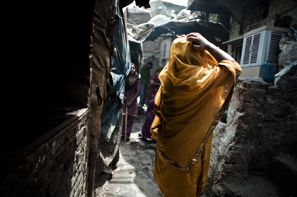 A woman adjusts her sari in the colony's tight alleys.
