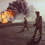 A U.S. Marine patrol walks across the charred oil landscape near a burning well near Kuwait City in March 1991. Concerns about oil supply were at play when the U.S. and its allies intervened during the Iraqi invasion of Kuwait in 1990. But American policy is changing now that Mideast oil imports to the U.S. are declining.