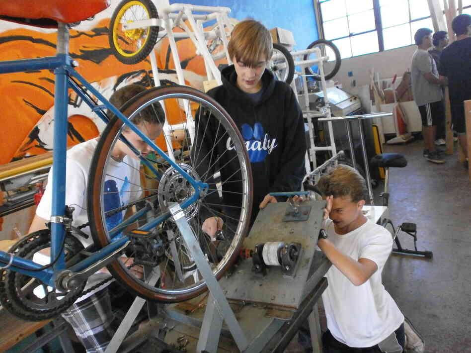 Students Blake Jamar (from left), Ryan Clifton and Gregory Gonzales take apart a bicycle that generates electricity at Analy High School in Sebastopol, Calif.
