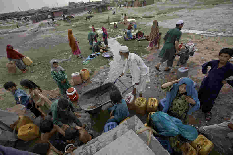Afghan refugees collect water from a water point in a slum area on the outskirts of Islamabad, in May. Afghan refugees collect water from a water point in a slum area on the outskirts of Islamabad, in May.