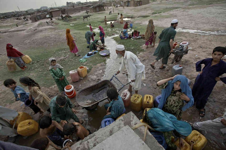 Afghan refugees collect water from a water point in a slum area on the outskirts of Islamabad, in May. Afghan refugees collect water from a water point in a slum area on the outskirts of Islamabad, in May.