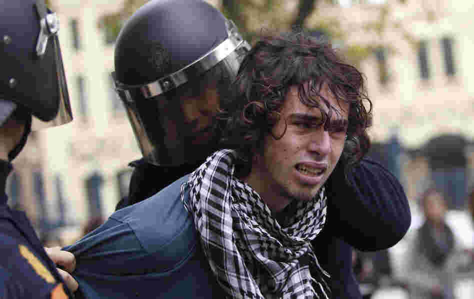 Riot policemen arrest a protester in Valencia on Wednesday during a general strike.