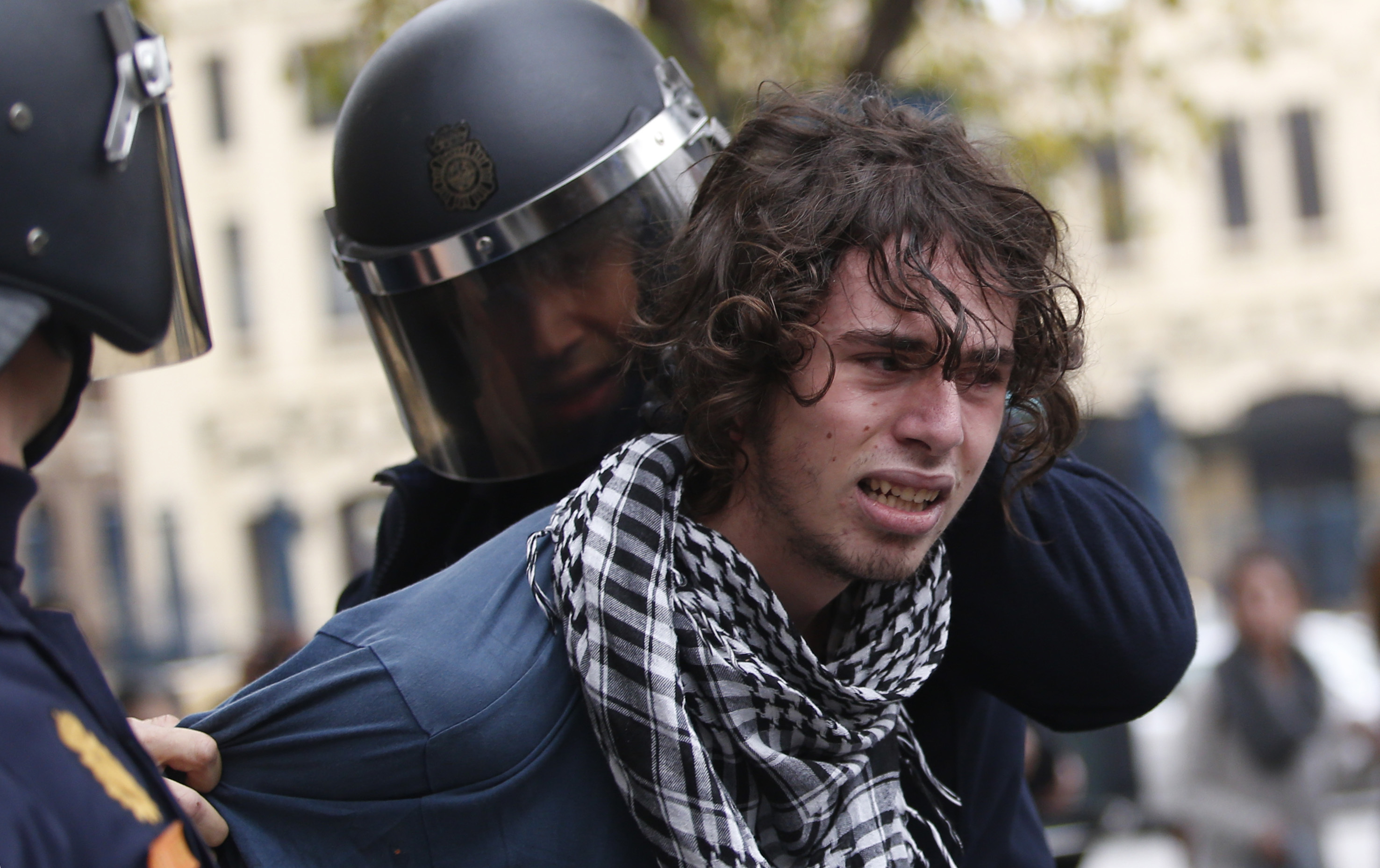 Riot policemen arrest a protester in Valencia on Wednesday during a general strike . Riot policemen arrest a protester in Valencia on Wednesday during a general strike .