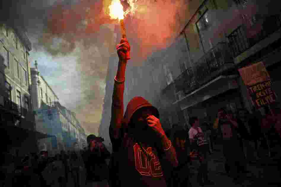 A protester holds a flare during a demonstration in Lisbon.